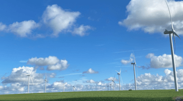 Blue sky with some cloud and windmills in foreground