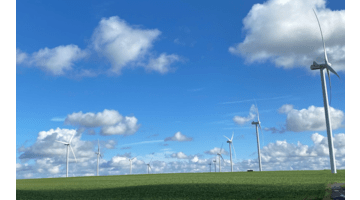 Blue sky with some cloud and windmills in foreground