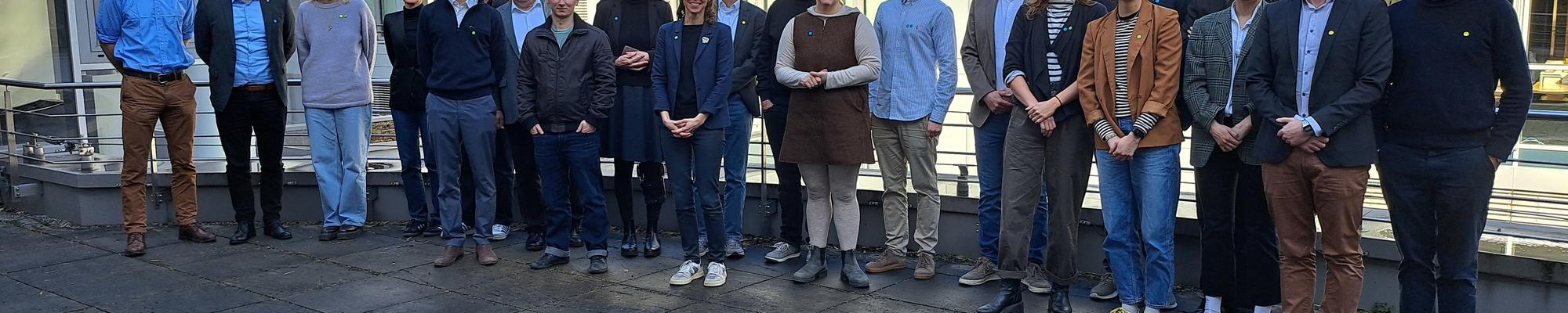 People stand in a row in front of a building